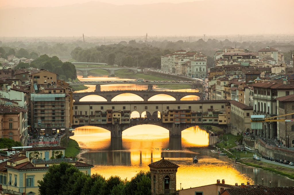 Arno river and famous Ponte Vecchio enlighten by the warm sunlight. Florence, Italy.